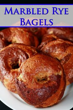 a white plate topped with baked goods on top of a blue and white sign that says marbled rye bagels