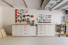 a garage with lots of tools on the wall and workbench in the center