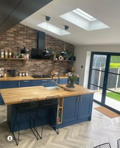 a kitchen with blue cabinets and wooden counter tops