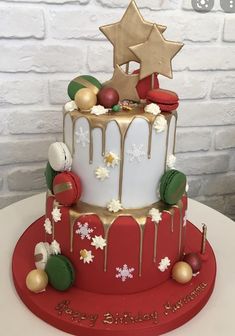 a christmas cake is decorated with gold, white and red decorations