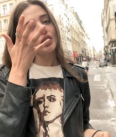 a woman making a hand gesture on the street