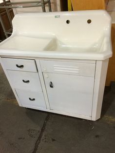 a white sink sitting on top of a wooden cabinet next to a counter with drawers