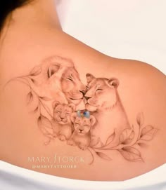 a woman with a tattoo on her back that has two lions and one lion cub