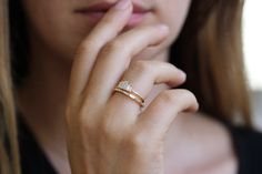 a close up of a person wearing a ring and holding her hand to her face