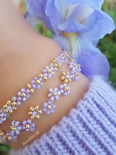 a close up of a person's arm wearing a bracelet with flowers on it