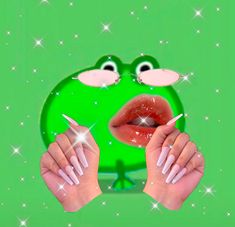 a woman's hands holding up a green frog face with white nails on it