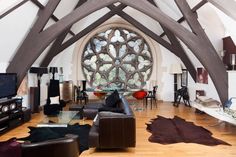 a living room filled with lots of furniture and a large window in the wall behind it