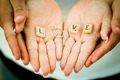 two hands holding letters that spell out love and the word marriage spelled with scrabbles