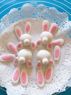 four bunny bunnies sitting on top of a white doily