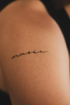 a woman's arm with a tattoo that reads, music