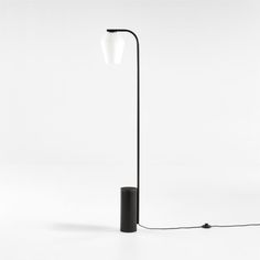 a black floor lamp with a white light on the top and an electric cord attached to it