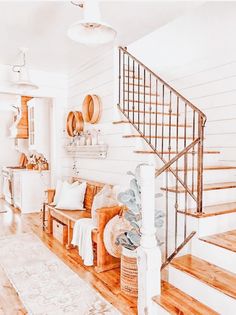 a living room filled with furniture next to a stair case and wooden floored stairs