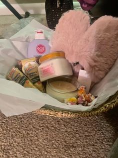 a teddy bear sitting in a basket filled with lots of food and condiments