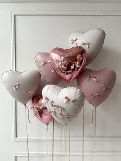 several heart shaped balloons are hanging on the wall