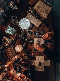 a person sitting at a table with some cards and other items on top of it