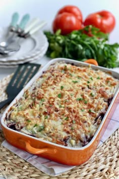 a casserole dish with cheese and vegetables in the background