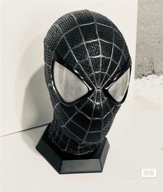 a black spider man mask is on display