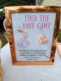 a sign that is on top of a table with a baby game in front of it