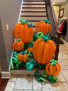 some pumpkins are sitting on the steps in front of a stair case with green and orange streamers