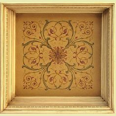 an ornate painting on the wall in a white frame with gold trimmings and red flowers