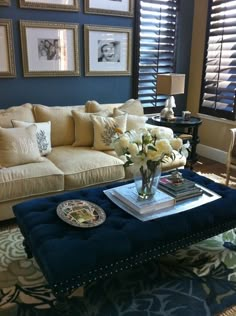 a living room filled with furniture and pictures on the wall above it's coffee table