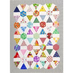 a colorful quilt is hanging on the wall in front of a black and white checkered background