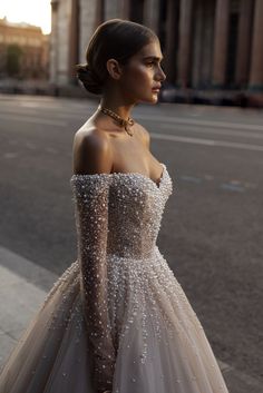 a woman is standing on the street wearing a dress with sequins and beads