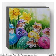 an easter card with three little mice in colorful eggs and daffodils on the grass