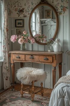 a bedroom with floral wallpaper and a mirror on the wall above a small table