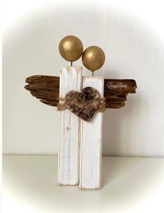 two wooden sticks with hearts on them and some gold balls in the middle, sitting next to each other