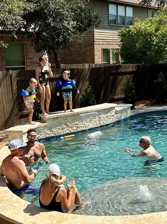 a group of people playing in a swimming pool with kids and an adult watching from the side