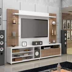 an entertainment center with speakers and a flat screen tv mounted on it's wall