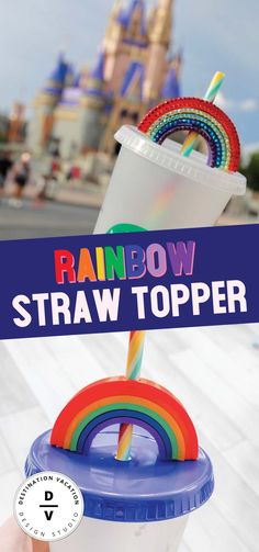 someone holding up a straw topper in front of a castle with the words rainbow on it