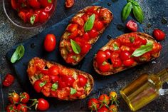 sliced bread topped with tomatoes and basil next to olives