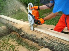 a man using a chainsaw to cut down a tree