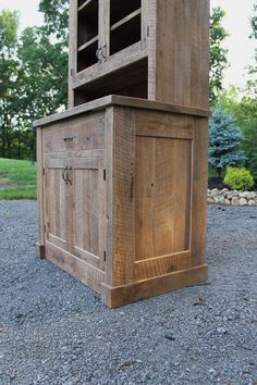 a large wooden cabinet sitting on top of gravel