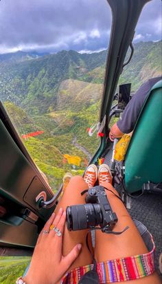 a person sitting in the cockpit of a plane with their legs crossed and holding a camera