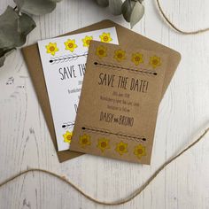 save the date cards with yellow flowers on them next to eucalyptus leaves and twine