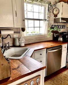 a kitchen with a sink, dishwasher and wooden counter top next to a window