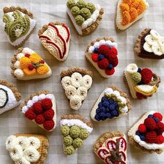 there are many small crocheted sandwiches on the table with fruit and veggies