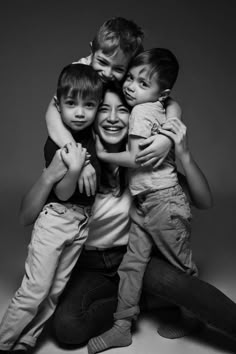 a black and white photo of four children hugging each other