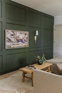 a living room with green painted walls and two couches in front of a coffee table