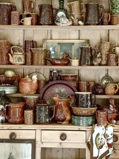 a shelf filled with lots of different types of cups and saucers on top of wooden shelves