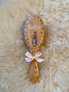 a wooden spoon with a bunny on it sitting on top of a fluffy white rug