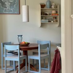 a dining room table and chairs in front of a chalkboard with a drawing on it