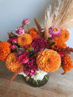 a vase filled with lots of different colored flowers