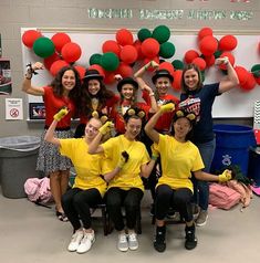 a group of young people posing for a photo in front of balloons and streamers