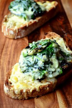 two pieces of bread with spinach and cheese on them