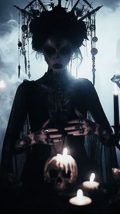 a woman dressed in black holding candles