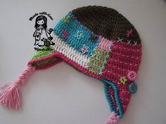 a crocheted hat with buttons and tassels